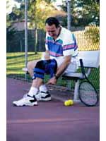 Picture of a man wearing a knee-brace, playing tennis