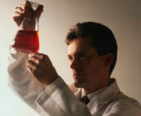 Picture of a male pathologist examining a container of liquid