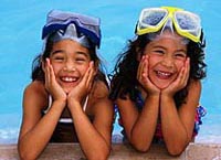 Picture of two young girls giggling by the side of the pool