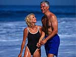 Picture of a middle-aged couple in swimsuits playing on the beach 